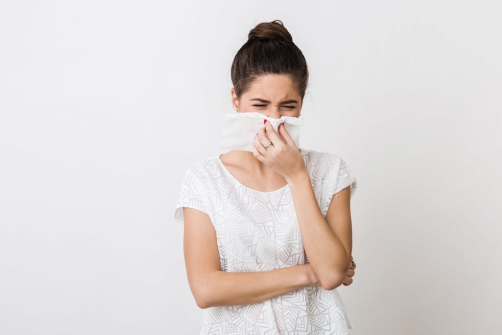 close up portrait of pretty woman blowing her nose with napkin catch cold feeling sick isolated frowning min scaled